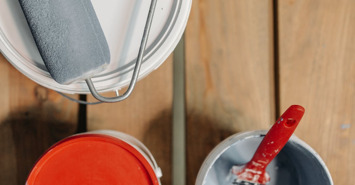 Paint cans and brushes arranged on wooden boards, ready for renovation work.